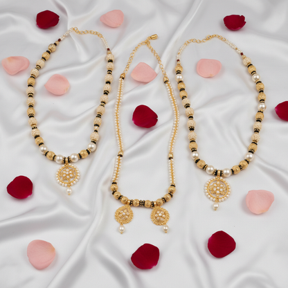 Pack of 4 gold-plated mangalsutra necklaces with moti beads flat lay on white silk